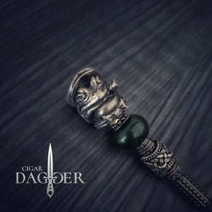 May include: A silver charm with a frog design, a green glass bead, and a silver bead with a Celtic knot design. The charm is attached to a silver chain.