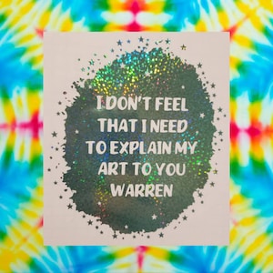 May include: A holographic sticker with a black circle and white stars. The text inside the circle reads "I don't feel that I need to explain my art to you Warren".