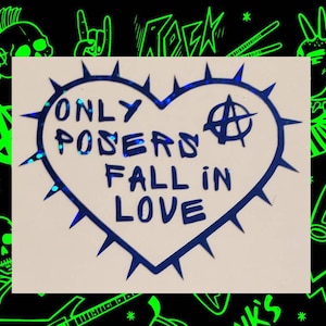 Op de afbeelding: Een blauwe sticker in de vorm van een hart met een punkrock-esthetiek. De sticker heeft een stekelige omtrek en zegt "Only Posers Fall in Love" met een anarchiesymbool.