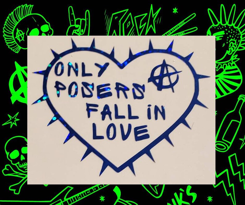 Op de afbeelding: Een blauwe sticker in de vorm van een hart met een punkrock-esthetiek. De sticker heeft een stekelige omtrek en zegt "Only Posers Fall in Love" met een anarchiesymbool.