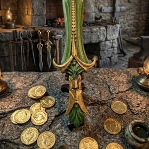 May include: A decorative green and gold dagger with a leaf design, set on a stone surface with gold coins. The background shows a blacksmith's workshop with tools and a fireplace, evoking a fantasy setting.