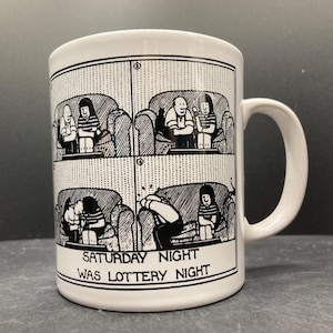 Peut inclure: Mug en céramique blanche avec un dessin de bande dessinée en noir et blanc. La tasse présente une illustration en quatre panneaux de personnes sur des canapés et le texte "SATURDAY NIGHT WAS LOTTERY NIGHT."