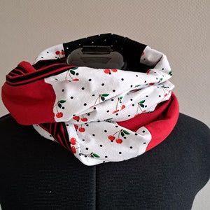 Könnte beinhalten: Ein roter, weißer und schwarzer Infinity-Schal mit einem Kirschendruck. Der Schal ist aus einem weichen, dehnbaren Stoff gefertigt und perfekt, um sich im Winter warm zu halten.