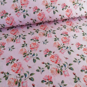 Könnte beinhalten: Rosafarbener Stoff mit einem sich wiederholenden Muster aus weißen und rosafarbenen Rosen mit grünen Blättern.