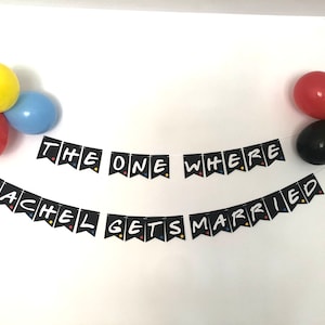 May include: Black and white banner with the text "The One Where Rachel Gets Married" in a Friends TV show theme style. The banner is decorated with colorful balloons.