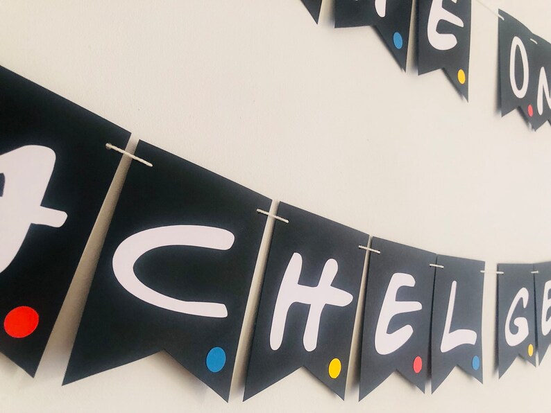 May include: Black and white banner with the words "Friends" in white letters on black triangles. Each triangle has a small colored dot in the corner. The colors are red, yellow, and blue.