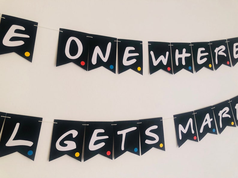 May include: Black and white banner with the text "The One Where... Gets Married" in a white, handwritten font. The banner is decorated with colorful dots.