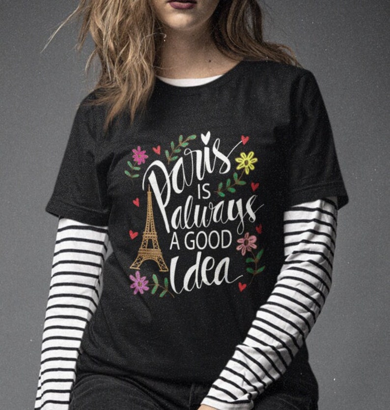 May include: Black t-shirt with a white graphic that says "Paris is always a good idea" with a drawing of the Eiffel Tower and flowers.