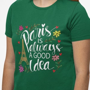 May include: Green t-shirt with a white graphic that says "Paris is always a good idea" with a drawing of the Eiffel Tower and flowers.