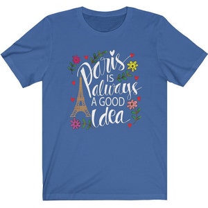 May include: A royal blue t-shirt with a white graphic design featuring the Eiffel Tower and the text "Paris is always a good idea" surrounded by flowers and hearts.