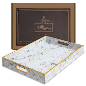 May include: A rectangular serving tray with a white marble design and gold geometric lines. The tray has a gold trim and cut-out handles. The brown box behind the tray has the logo "willow and moore" printed on it.