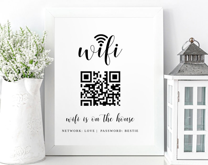 May include: A white framed sign with black text that reads "wifi" with a wifi symbol above the word. Below the word is a black and white QR code. Below the QR code is the text "wifi is on the house" with the text "NETWORK: LOVE | PASSWORD: BESTIE" below that.