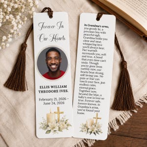 May include: Two white rectangular memorial bookmarks with dark brown tassels. The left bookmark features a circular photo of a man, the text Forever In Our Hearts, the name Ellis William Theodore Ives, dates, and a candle with a cross and flowers.