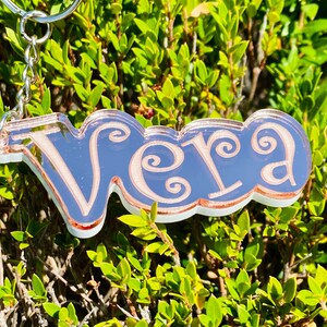 May include: A rose gold keychain with the name "Vera" written in a decorative script font.