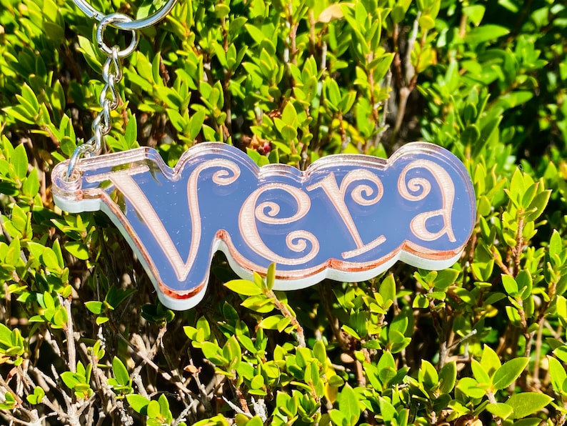 May include: A rose gold keychain with the name "Vera" written in a decorative script font.