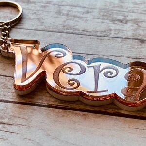 May include: Rose gold keychain with the name "Vera" engraved in a decorative font.