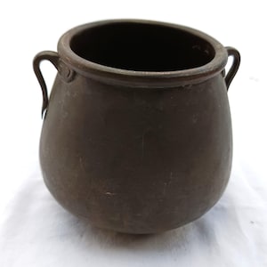 May include: A white ceramic mug with a black handle and the text "But First, Coffee" in a bold, black font. The mug is sitting on a wooden surface. The mug is approximately 4 inches tall.