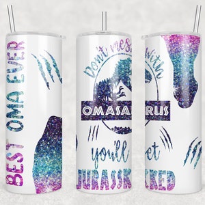 May include: A white tumbler with a pink, blue, and purple glitter design. The tumbler has a straw and features a dinosaur silhouette with the text "Don't mess with Oma'saurus you'll get Jurassic'd".