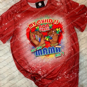 May include: Red t-shirt with a distressed white pattern. The shirt features a graphic with the text "MY CHILD IS NON VERBAL BUT HER MAMA AIN'T" and illustrations of hands holding puzzle pieces.