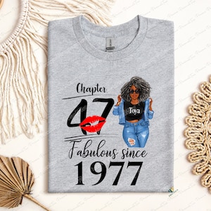 May include: Gray t-shirt with the text "Chapter 47 Fabulous since 1977" and a red lip print. A cartoon woman with black hair and sunglasses is wearing a denim jacket and jeans.