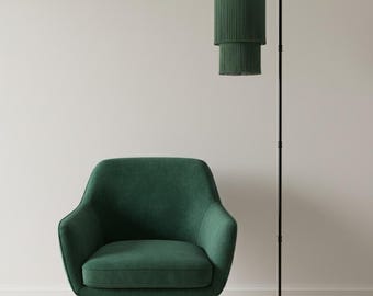 Lámpara de pie arqueada con pantalla con flecos escalonados.