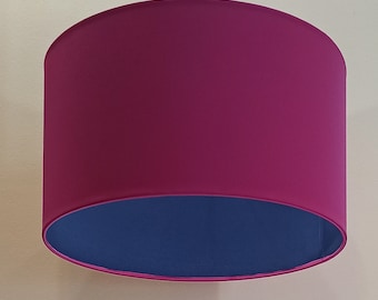 Könnte beinhalten: Ein zylindrischer Lampenschirm in Pink und Blau. Die obere Hälfte des Lampenschirms ist pink, die untere Hälfte blau.