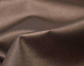 May include: Close-up of a smooth, brown fabric with a subtle sheen. The fabric has a fine, even texture and a slightly wrinkled appearance.