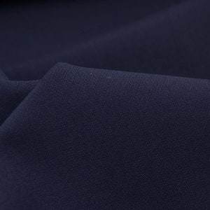 May include: Close-up of a dark blue fabric with a subtle textured weave. The fabric has a smooth, soft appearance.