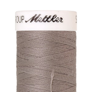 May include: A spool of gray thread with the text "GROUP Mettler" on the label.