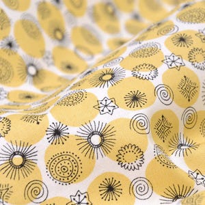 May include: Yellow fabric with a white background featuring a repeating pattern of yellow circles with black and white geometric designs.
