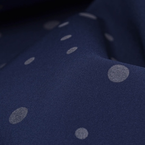 Könnte beinhalten: Nahaufnahme eines dunkelblauen Stoffes mit weißen Punkten. Der Stoff ist strukturiert und fühlt sich weich und glatt an.