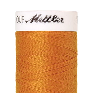May include: A spool of orange thread with the text "Metzler Group" on the label.