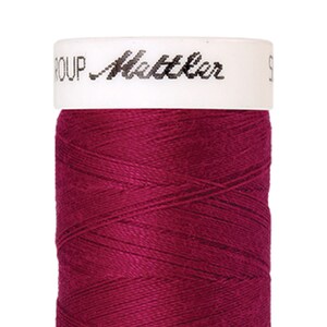 Könnte beinhalten: Eine Spule mit tiefrotem Garn in Burgunderrot mit einem weißen Etikett, auf dem "GROUP Mettler" steht.