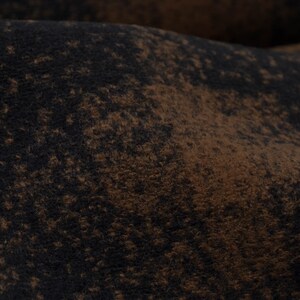 以下が含まれることがあります： 茶色と黒のざらざらした質感の布のクローズアップ。まだら模様になっている。