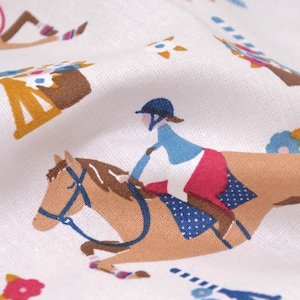 Könnte beinhalten: Weißer Stoff mit einem sich wiederholenden Muster aus einem braunen Pferd und einer Person, die das Pferd reitet. Die Person trägt ein blaues und rotes Outfit und einen blauen Helm. Der Hintergrund ist weiß mit kleinen Blumenmustern.