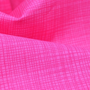 以下が含まれることがあります： ピンクの生地のクローズアップ。細かい格子模様が入っています。生地は柔らかく、質感があります。