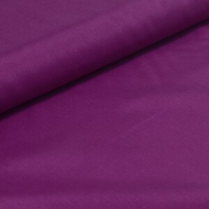 May include: A smooth, solid purple fabric with a slight sheen. The fabric is folded in half, with one side lying flat and the other side folded over it.