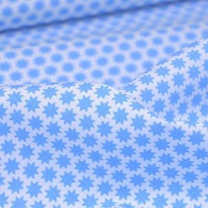 Pode incluir: Tecido branco com um padrão repetitivo de estrelas azul claro.