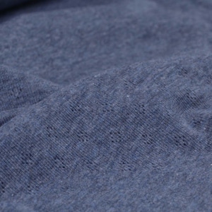 May include: Close-up of a blue textured fabric with a subtle pattern. The fabric has a soft, slightly fuzzy texture.