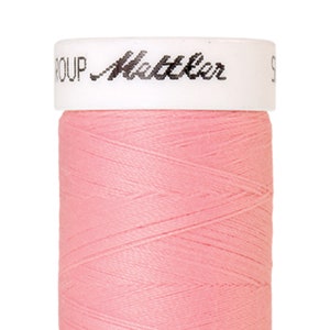 Könnte beinhalten: Eine Spule pinkfarbenen Garns mit dem Text "Metzler Group" auf dem Etikett.