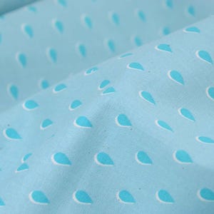 May include: Light blue fabric with a white and turquoise raindrop pattern.