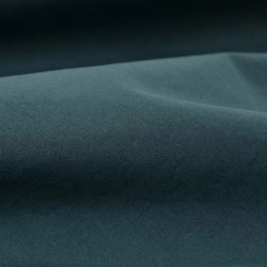 May include: Close-up of a dark teal fabric with a smooth, even texture. The fabric is folded and draped, creating soft curves and folds.