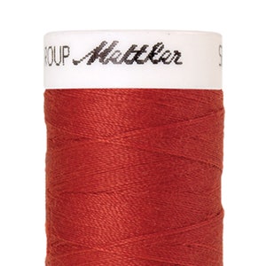 May include: A spool of red thread with the text "GROUP Mettler" on the label.