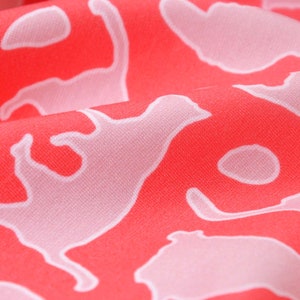 May include: Red fabric with a white repeating pattern of stylised animal silhouettes.