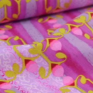 Peut inclure: Gros plan sur un tissu avec un motif répété de baies roses et rouges, de tiges jaunes et de feuilles vertes. Le fond présente des rayures verticales dans les tons de rose et de violet. Le tissu est plié, montrant sa texture.