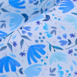 Puede incluir: Una tela azul claro con un patrón repetitivo de flores y hojas azules. El fondo es de color azul claro.