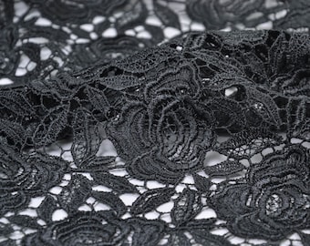 May include: Black lace fabric with a delicate floral pattern. The lace is intricate and has a soft, flowing texture.