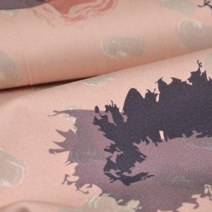 May include: A close-up of a pink fabric with a dark grey abstract print. The print resembles a cluster of trees or a forest.