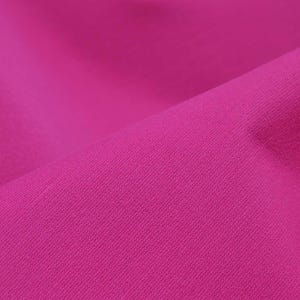 May include: Close-up of a vibrant magenta fabric with a smooth, slightly textured surface.