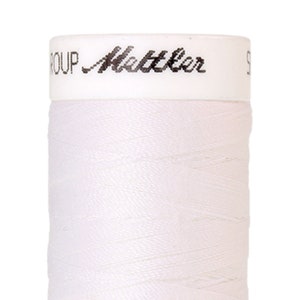 May include: A white spool of thread with the text "GROUP Mettler" printed on the top.